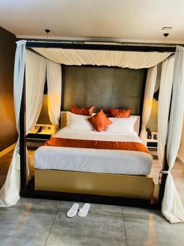 Un dormitorio con una cama grande con dosel. en Boun's Hotel, en Yaoundé