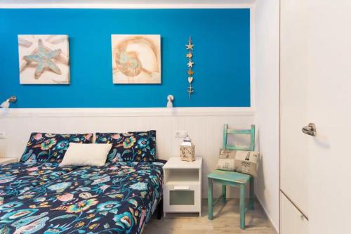 um quarto com uma cama e uma parede azul em Acogedor y vistas al mar em Maspalomas