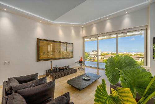 a living room filled with furniture and a large window at 5bph-coral15 - Oceanfront Exclusive Penthouse With Stunning Views And Private Pool Home-theater Included, in Oranjestad