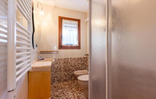 a bathroom with a toilet and a sink and a mirror at 2 Bedroom Lovely Home In Orba in Orba