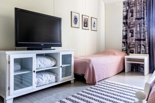 una sala de estar con TV de pantalla plana en un armario blanco en Villa Korkatti, en Haapavesi