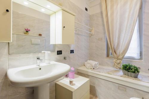 a white bathroom with a sink and a bath tub at SORRIDI AL LAGO in Sirmione