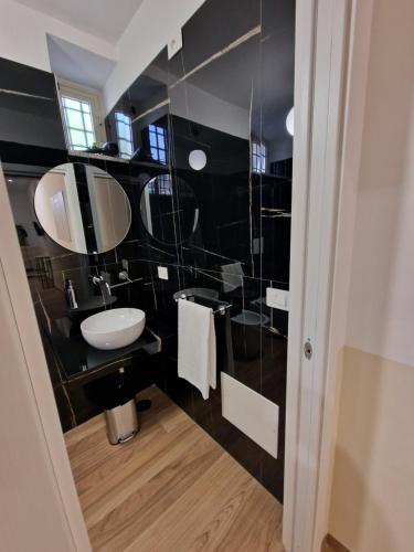 a black and white bathroom with a sink and mirror at DoMa house b&b in Nocera Inferiore