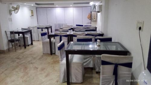 un comedor con mesas y sillas en una habitación en Hotel Jeniffer Inn, en Nueva Delhi