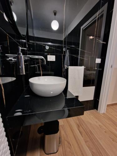 a bathroom with a sink and a black wall at DoMa house b&b in Nocera Inferiore