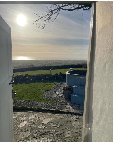 an open door with a view of a green field at Carrick Cottage - Mourne Mountains in Annalong