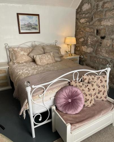 um quarto com uma cama branca com almofadas em Carrick Cottage - Mourne Mountains em Annalong