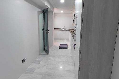 um corredor com uma cozinha e uma porta para um quarto em Luxe Modern 3 BR City Center TNGR w. Superfast Wifi & AC em Tânger