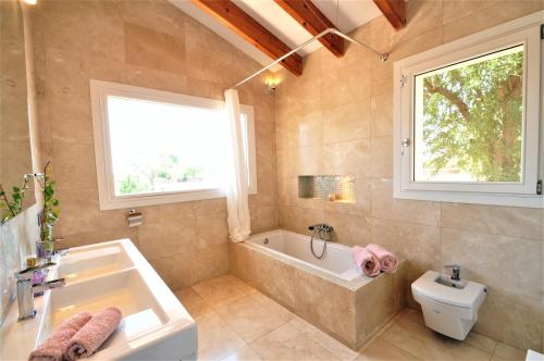 a bathroom with a tub and a sink and a toilet at Casa Calma in Llucmajor