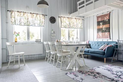 ein Wohnzimmer mit einem blauen Sofa und einem Tisch und Stühlen in der Unterkunft Villa Korkatti in Haapavesi