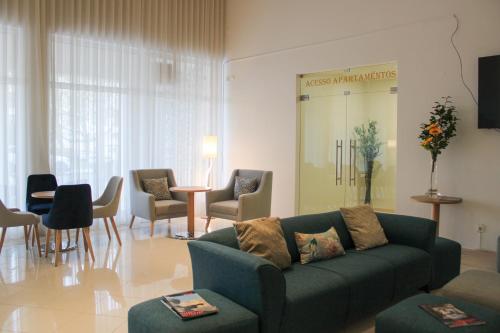 a living room with a couch and a table and chairs at Hotel Francis in Beja