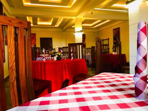 um quarto com duas mesas com toalha de mesa vermelha e branca em Kerama Silent Lodge em Arusha