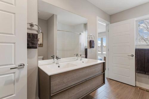a white bathroom with a sink and a mirror at Luxury Home: Monthly Rental House Near Denver in Englewood
