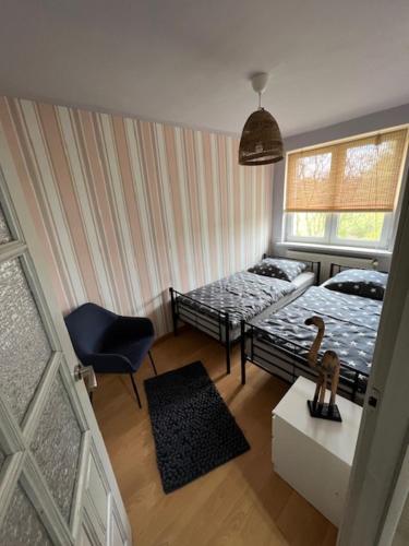a small room with two beds and a chair at Mieszkaj U Marty in Jaworzno