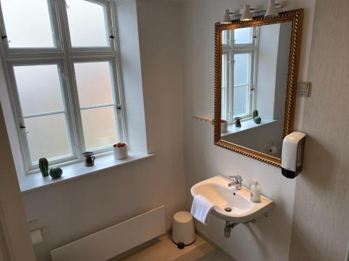 a bathroom with a sink and a mirror at Marsk Hotel Apartments 6B, 1 - TV in Højer
