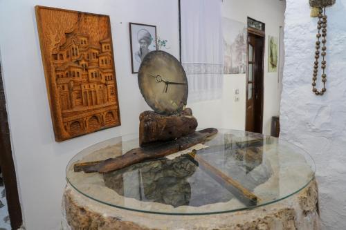 eine Uhr, die auf einem Glastisch sitzt in der Unterkunft Edward Lear in Berat