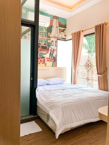 a bedroom with a bed and a painting on the wall at Kartiko Palagan Eksklusif Yogyakarta in Kejayan