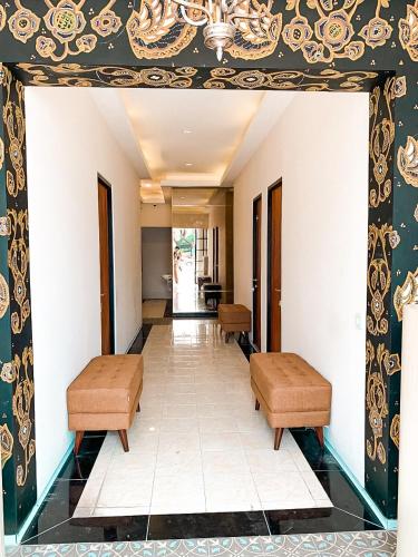 a hallway with two benches and a wall with a ceiling at Kartiko Palagan Eksklusif Yogyakarta in Kejayan