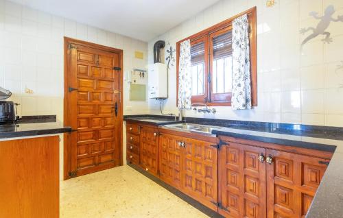 a kitchen with wooden cabinets and a sink and a window at 2 Bedroom Lovely Home In Orba in Orba