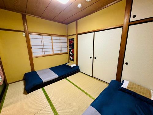 a small room with two beds and a window at 京墅-蓮 Kyosho Lotus in Kyoto
