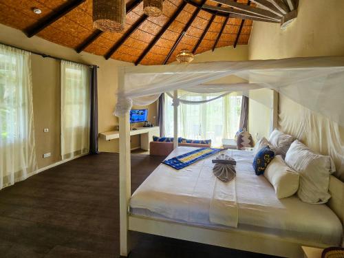 - une chambre avec un lit à baldaquin dans l'établissement Balafon Beach Resort, à Kololi