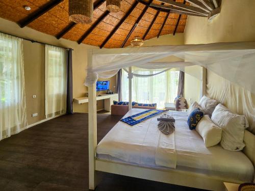 ein Schlafzimmer mit einem Himmelbett in einem Zimmer in der Unterkunft Balafon Beach Resort in Kololi