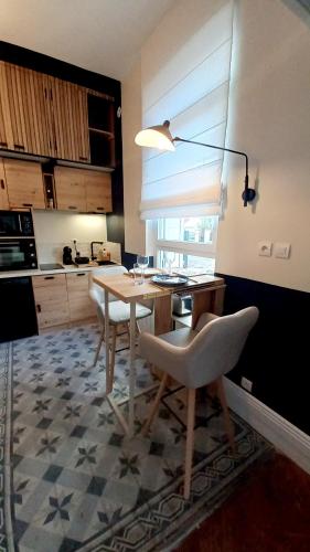 une cuisine avec une table, des chaises et une lampe dans l'établissement L'Elégant, à Le Petit-Quevilly