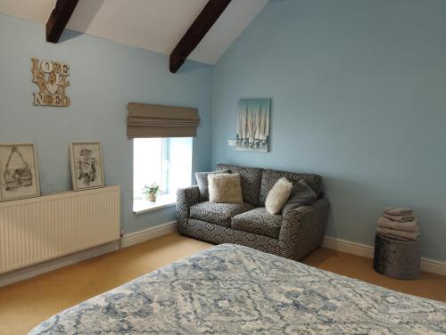 a bedroom with a bed and a couch and a window at Private Quay, Balcony, Sea Views, Free Parking in Pembrokeshire