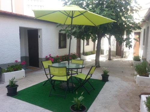 a patio with a table and chairs and an umbrella at Alojamento Local Duarte's in Coimbra