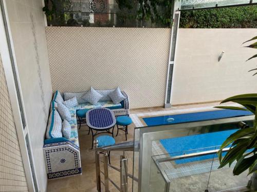 un patio con sillas, una mesa y una piscina en فيلا للاستمتاع, en El Harhoura