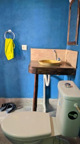 a bathroom with a toilet and a table with a sink at Café restaurante shelter calm life in Bou Dib