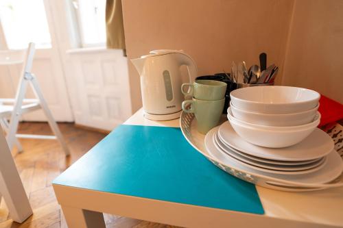 a table with plates and cups on top of it at Trzy Kafki Private Rooms in Kraków