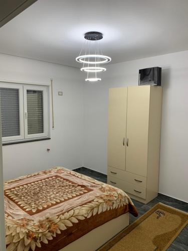 1 dormitorio con 1 cama, armario y lámpara de araña en Full luxury house for holidays in Albania,Shengjin en Lezhë