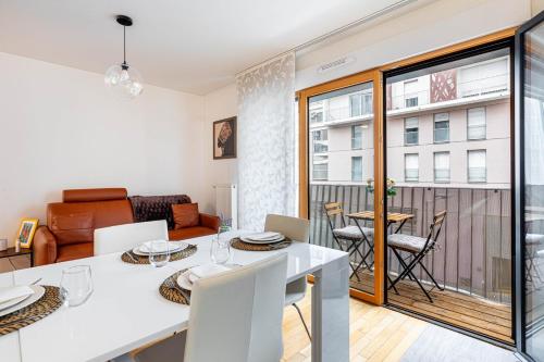 a kitchen and living room with a white table and chairs at GuestReady - Bright getaway near la Défense in Nanterre