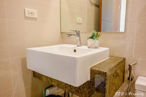 a bathroom with a white sink and a mirror at 56sqm. Condo at Mactan Newtown w/Free Beach and Pool Access! in Lapu Lapu City