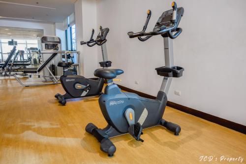 a gym with two exercise bikes in a room at 56sqm 2BR Condo at Mactan Newtown Pool and Beach Access! in Lapu Lapu City