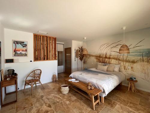 une chambre avec un lit et une table en bois dans l'établissement L' Inattendu, entre terre et mer !, à Laouque