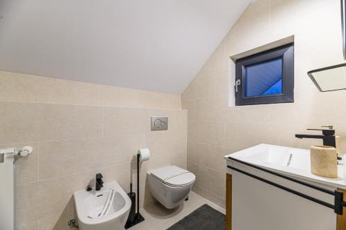 a bathroom with a toilet and a sink and a window at Doftana Lake House in Teşila