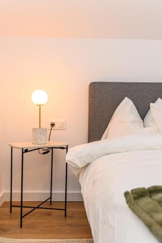 a bed with a side table with a lamp on it at Doftana Lake House in Teşila