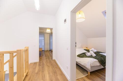 a bedroom with a bed and a hallway with a staircase at Doftana Lake House in Teşila