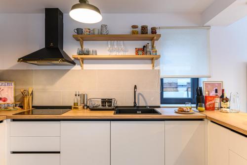 a kitchen with white cabinets and a sink at Doftana Lake House in Teşila