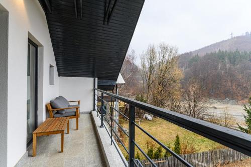 a balcony with a bench and a view of the mountains at Doftana Lake House in Teşila