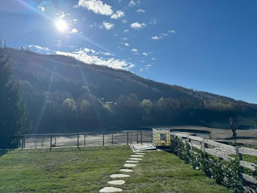 a field with a fence and a body of water at Doftana Lake House in Teşila