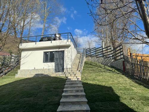 a staircase leading up to a building with a fence at Doftana Lake House in Teşila