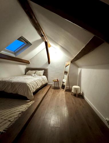 een slaapkamer op zolder met een bed en een raam bij Charmant Duplex proche de Paris in Saint-Brice-sous-Forêt