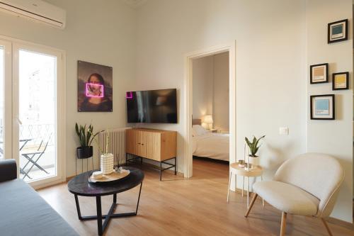 sala de estar con cama y TV en una habitación en Aristotelous 22 Suites, en Tesalónica
