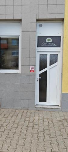 un edificio con una puerta blanca con un cartel. en Apartmán 2 Hradná 9 en Nové Zámky
