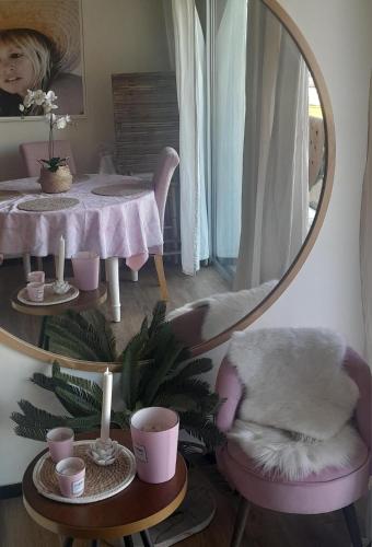 - un miroir rond dans une pièce avec une table et une chaise dans l'établissement Le Paradis Bleu, à Cavalaire-sur-Mer