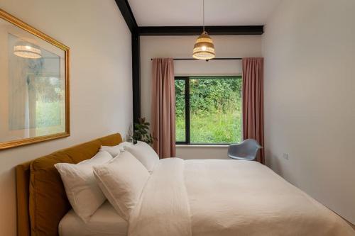 una camera con un grande letto e una finestra di Luxury Eco Escape in South Devon a Darlington