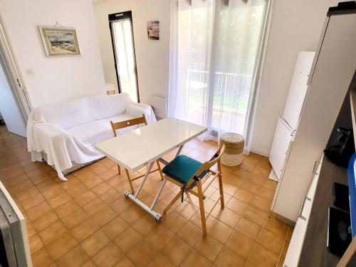 un salon avec une table et des chaises blanches dans l'établissement Appartement T3 avec Parking, Piscine, Tennis et Wi-Fi - À 200m des Plages et Commerces - FR-1-316-304, à Six-Fours-les-Plages